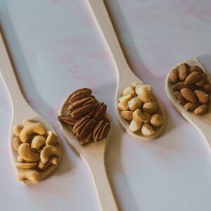 Close-Up Shot of Assorted Nuts on a Wooden Spoon